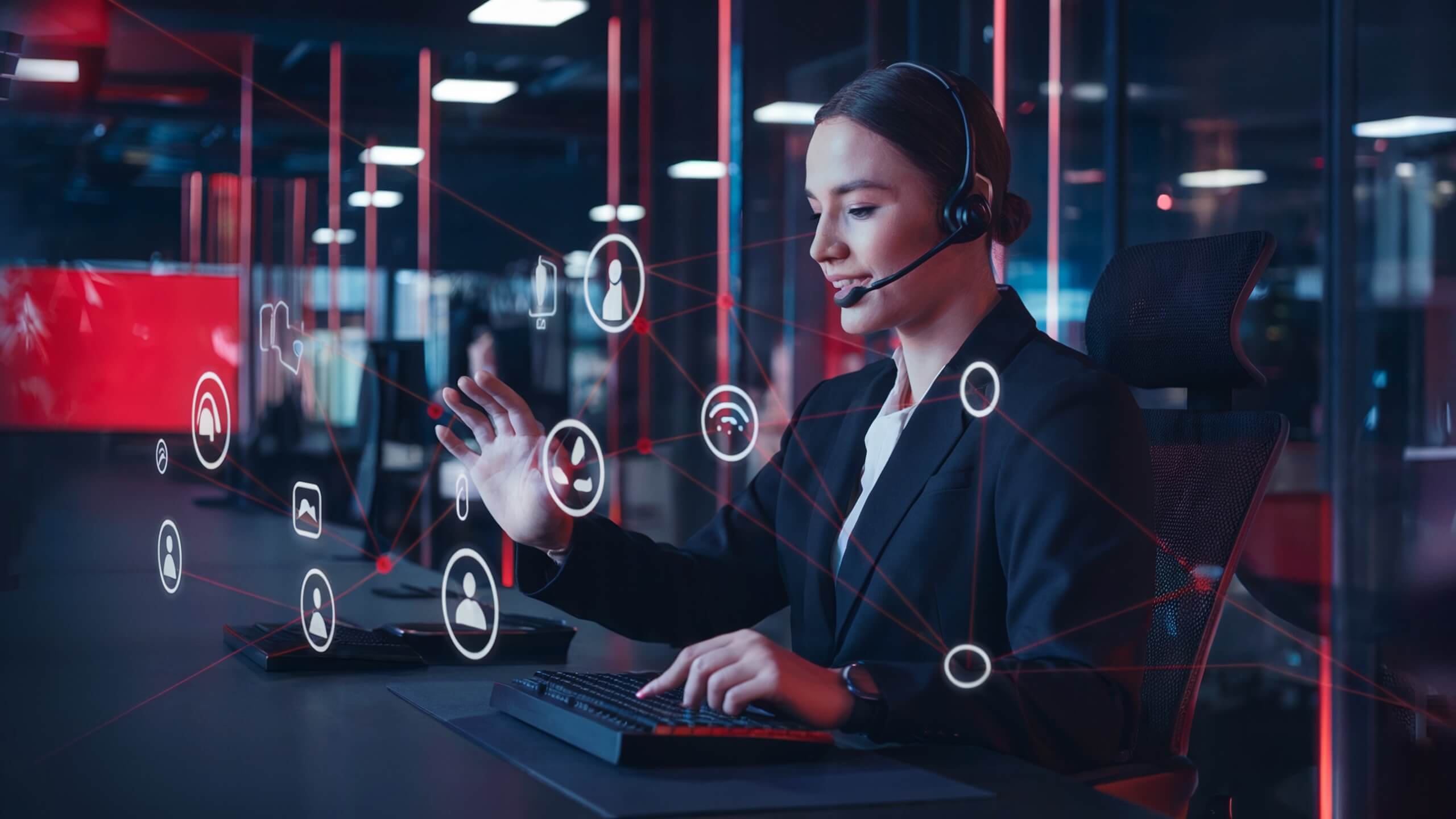 Woman wearing a headset working on a computer in a modern office, interacting with digital icons such as user profiles and network lines, representing digital communication and connectivity.